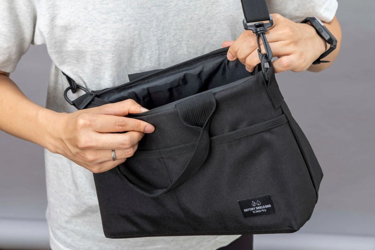 Person opening BATTERY SHIELD BAG