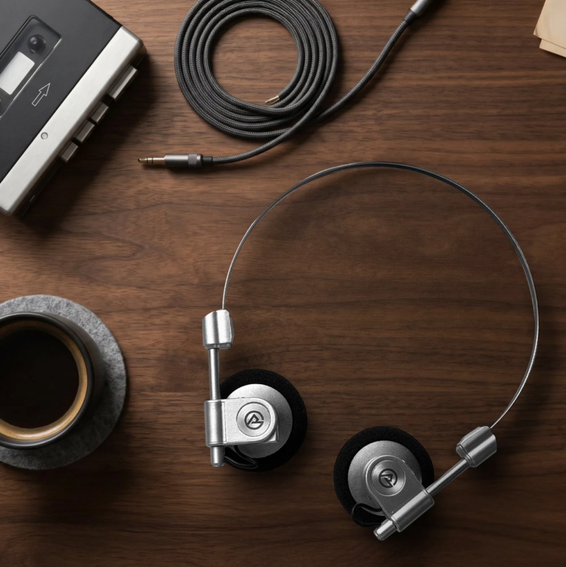 Retro cassette player, headphones, and coffee on a wooden table