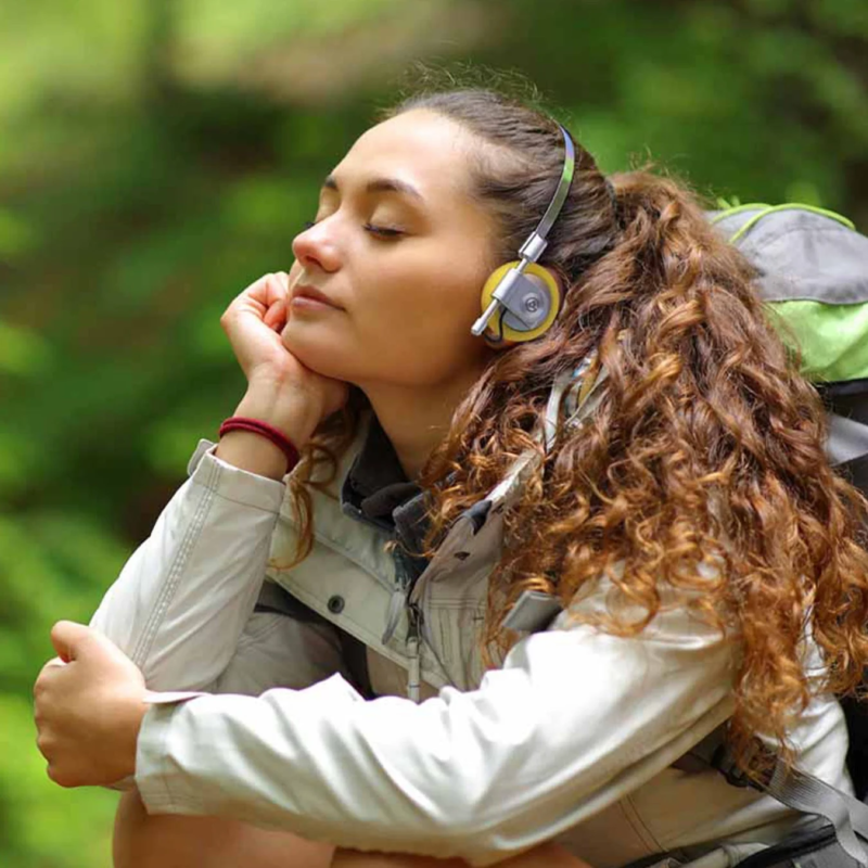 A woman relaxing with headphones in nature
