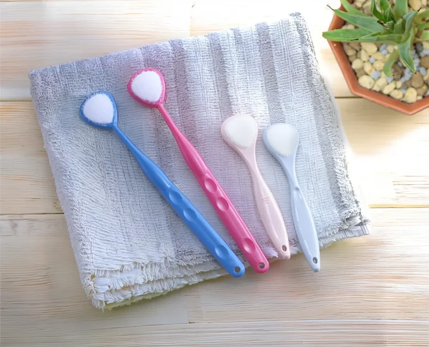 Colorful tongue cleaners on a wooden surface