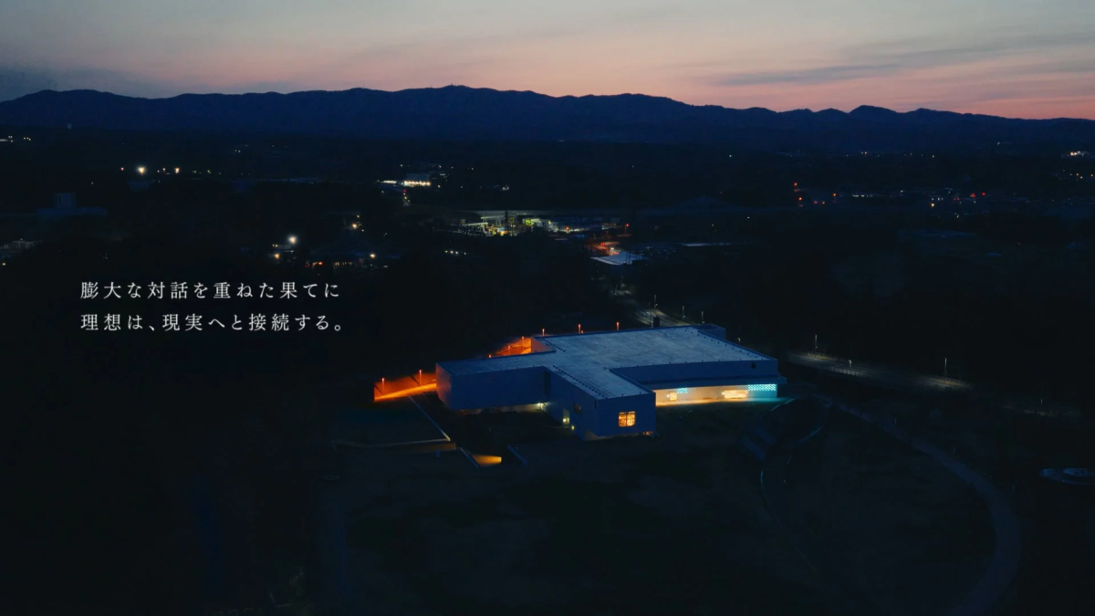 Night view of a building with text 'Ideals connect to reality through extensive dialogue.'