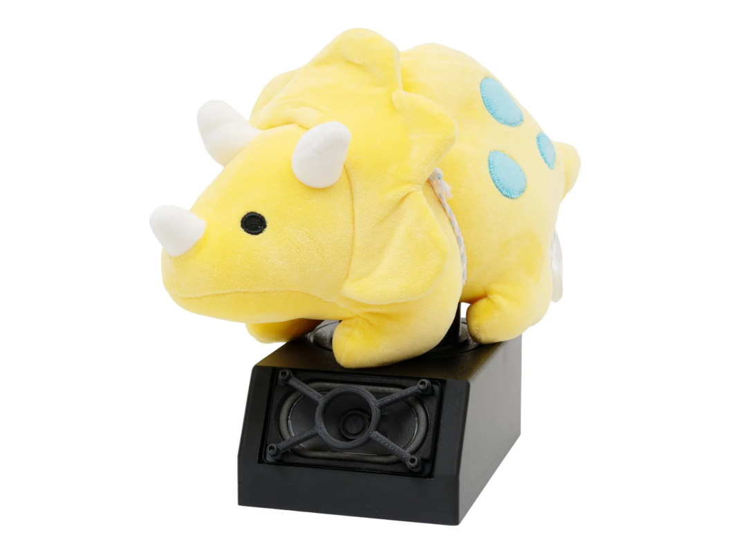 Yellow triceratops plushie on a black speaker