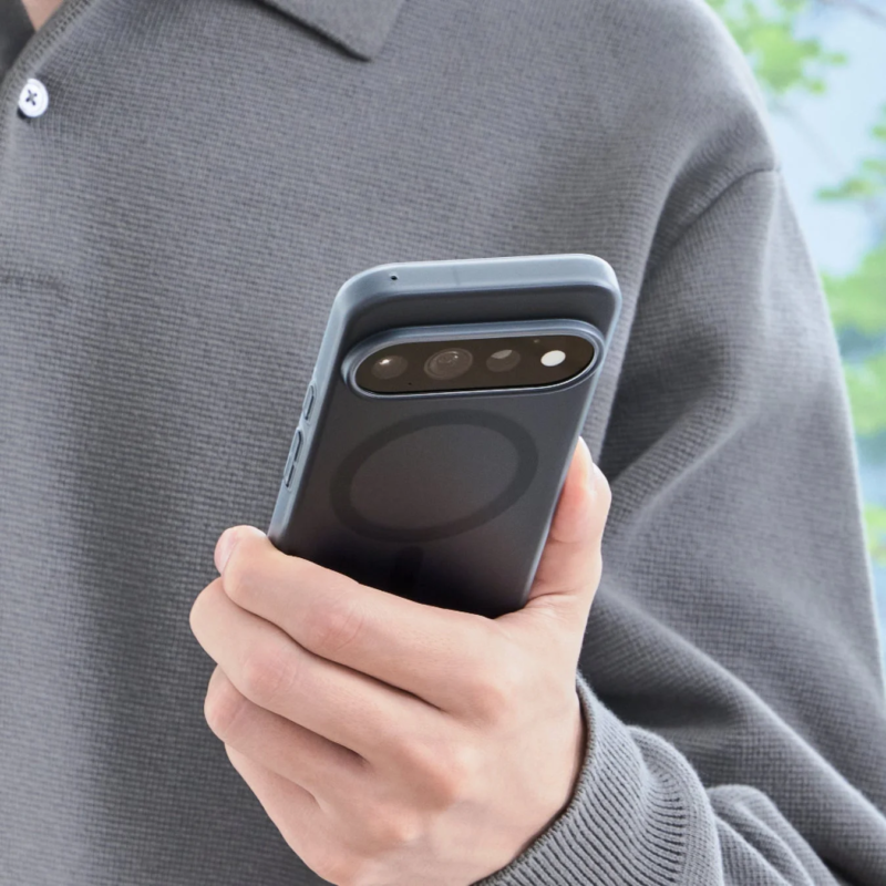 Person holding black smartphone case with multiple camera lenses and MagSafe ring