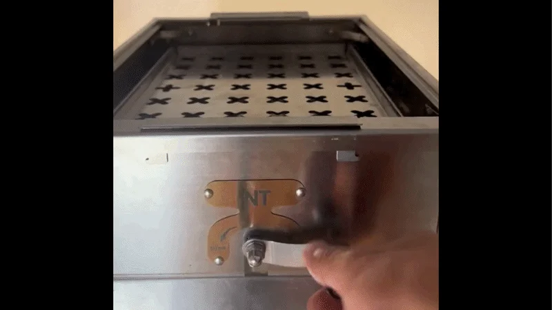 Hand operating a lever on the grill