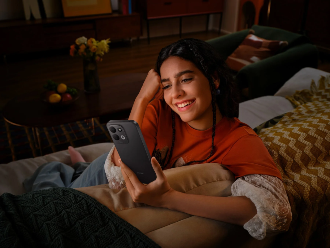 Young woman smiling while using a smartphone indoors