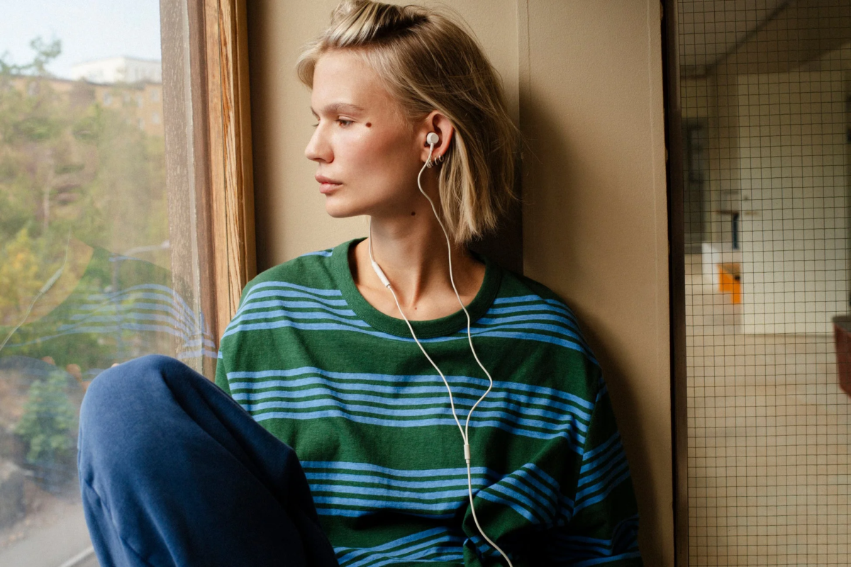 Woman with earphones by window