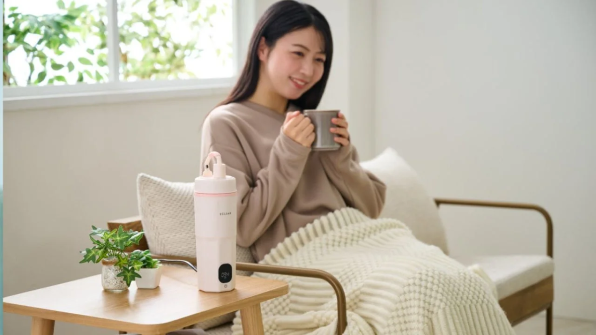 Woman drinking, kettle on table