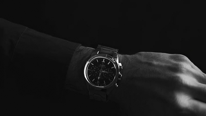 A close-up of a man's arm wearing a classic watch with a metal band