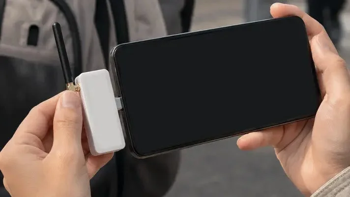 Person holding smartphone with Sonae Denpa attached